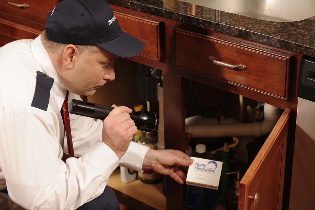 Home Paramount technician working under a customer's kitchen sink