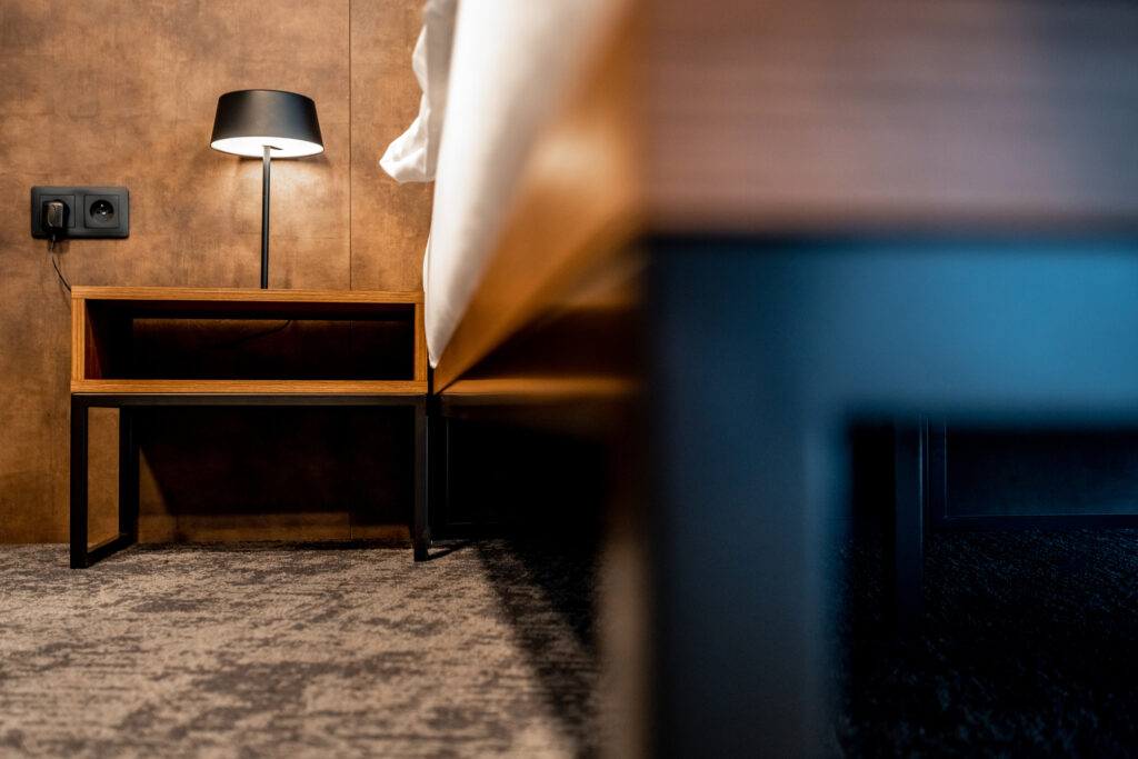 Low view of clean hotel room floor and bed.